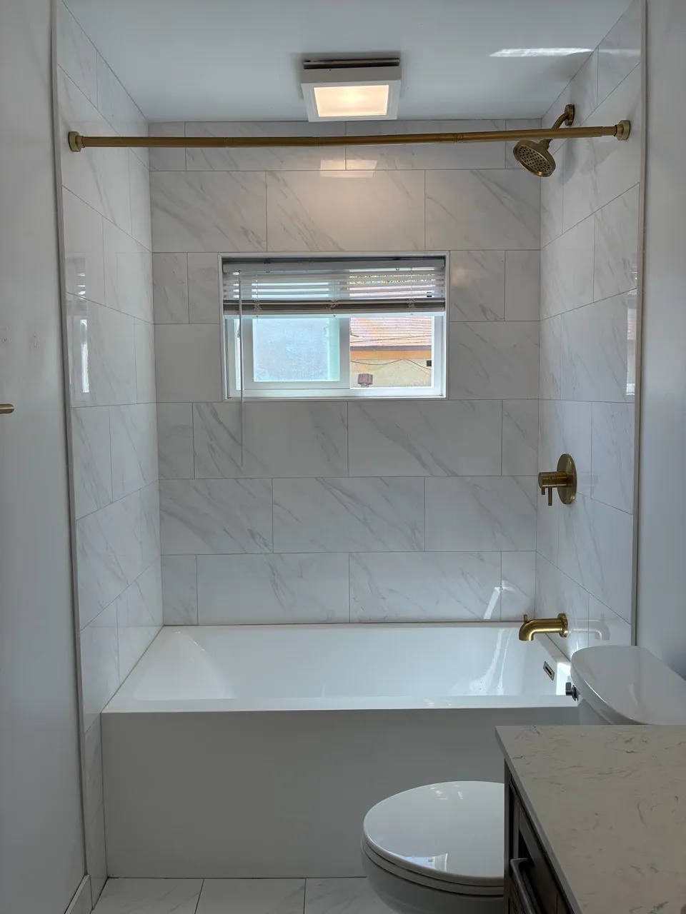 Glass-paneled shower with white tiled walls